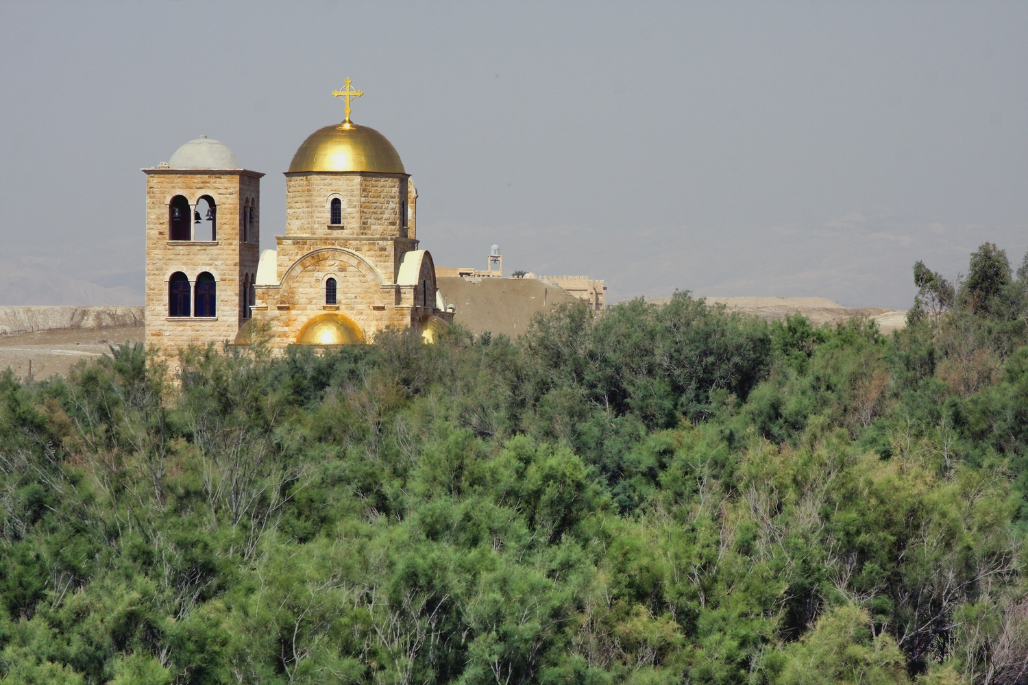 Лес на берегу реки Иордан. В лесу торчат самые разнообразные церкви и храмы. Этот - православный, греческий.
