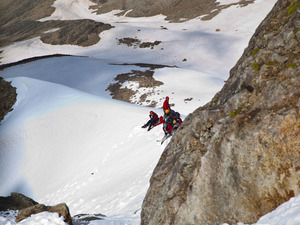 Группа на снежной перемычке под перевальным взлетом скалистого.