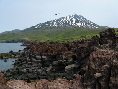 Остров Итуруп, лавовые выходы на полуострове Чирип.  На заднем плане вулкан Богдан Хмельницкий.
